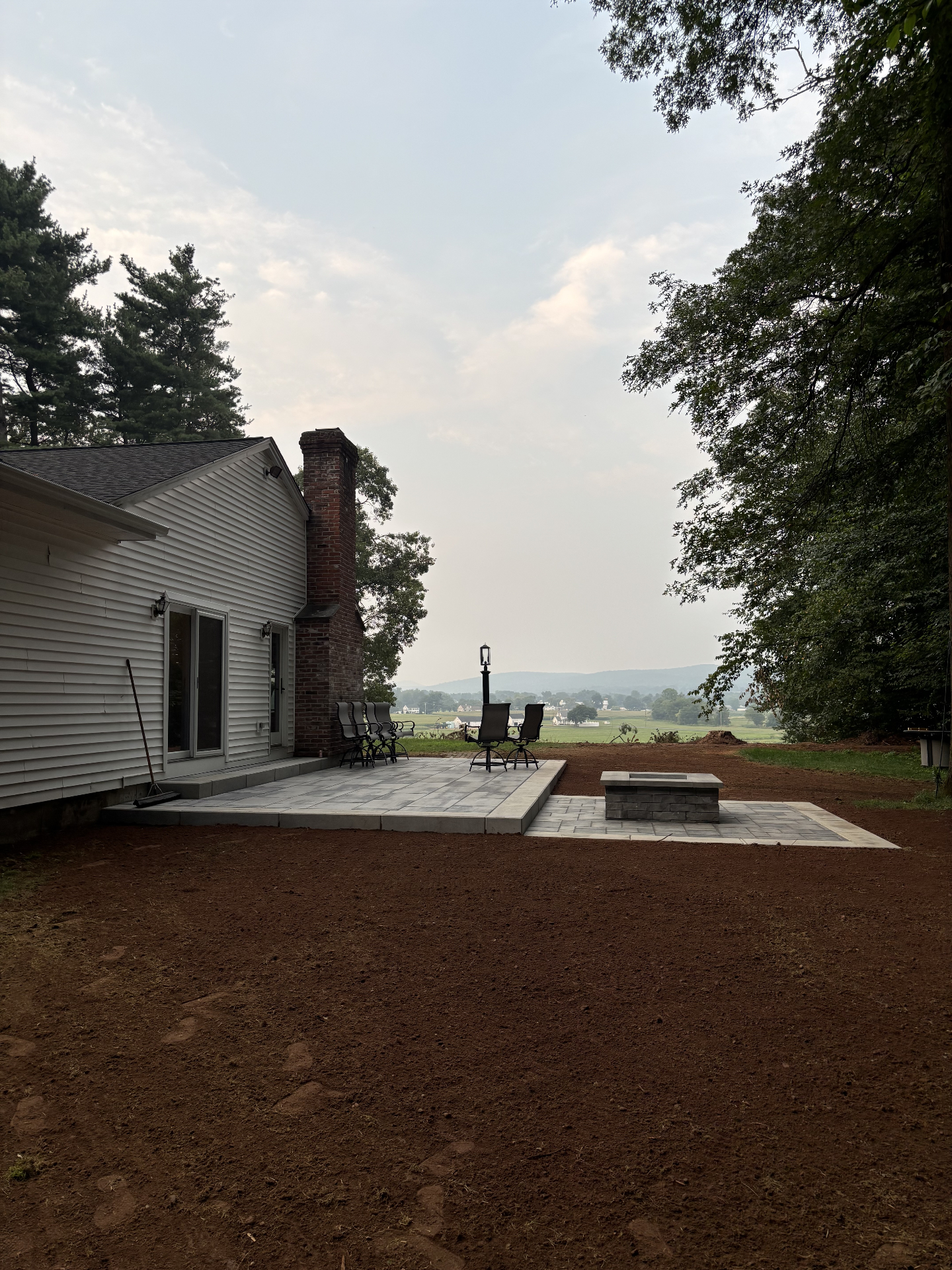 Paver patio with a stone fire pit overlooking the valley
