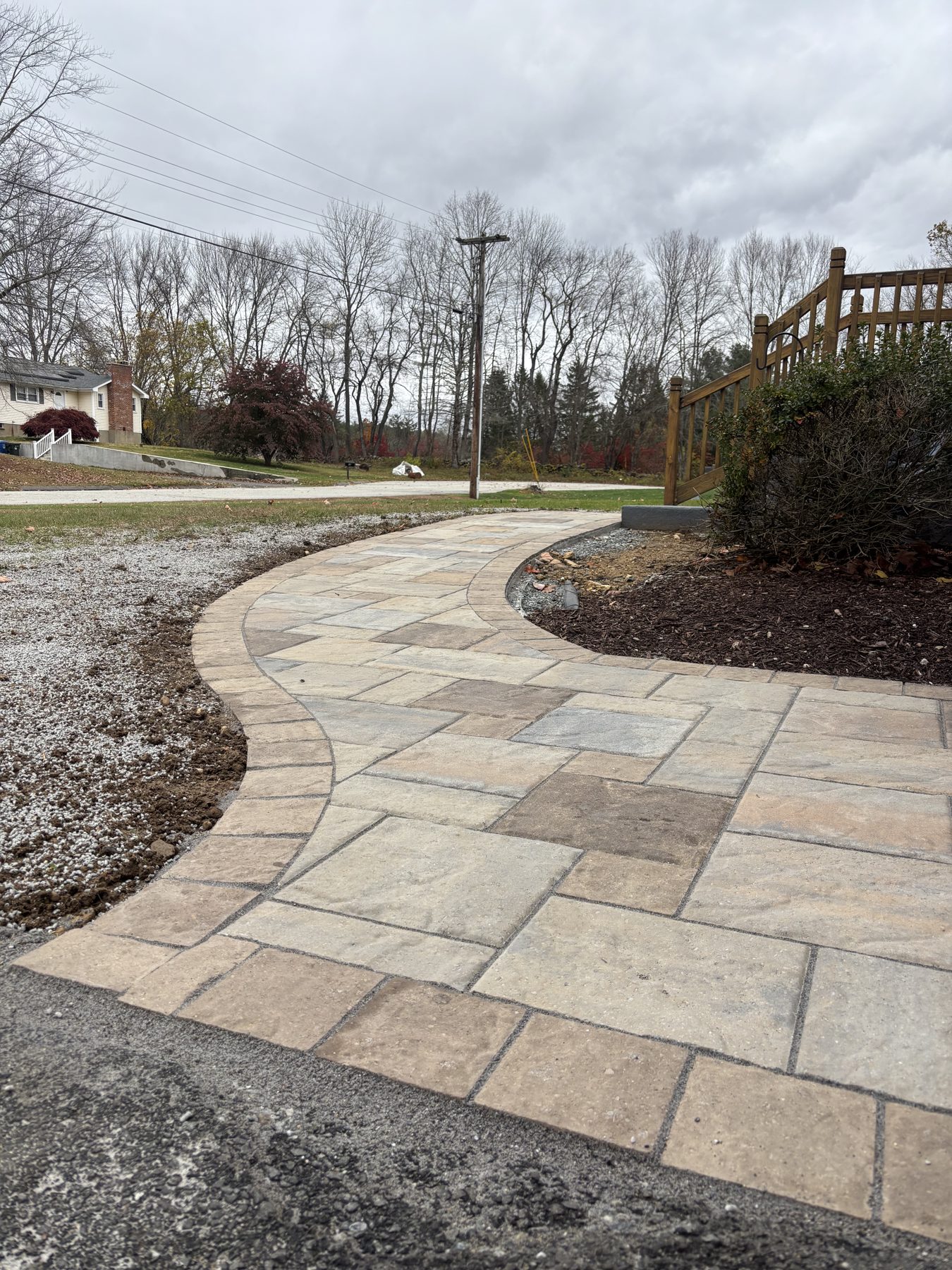 Curved paver walkway running through landscape beds