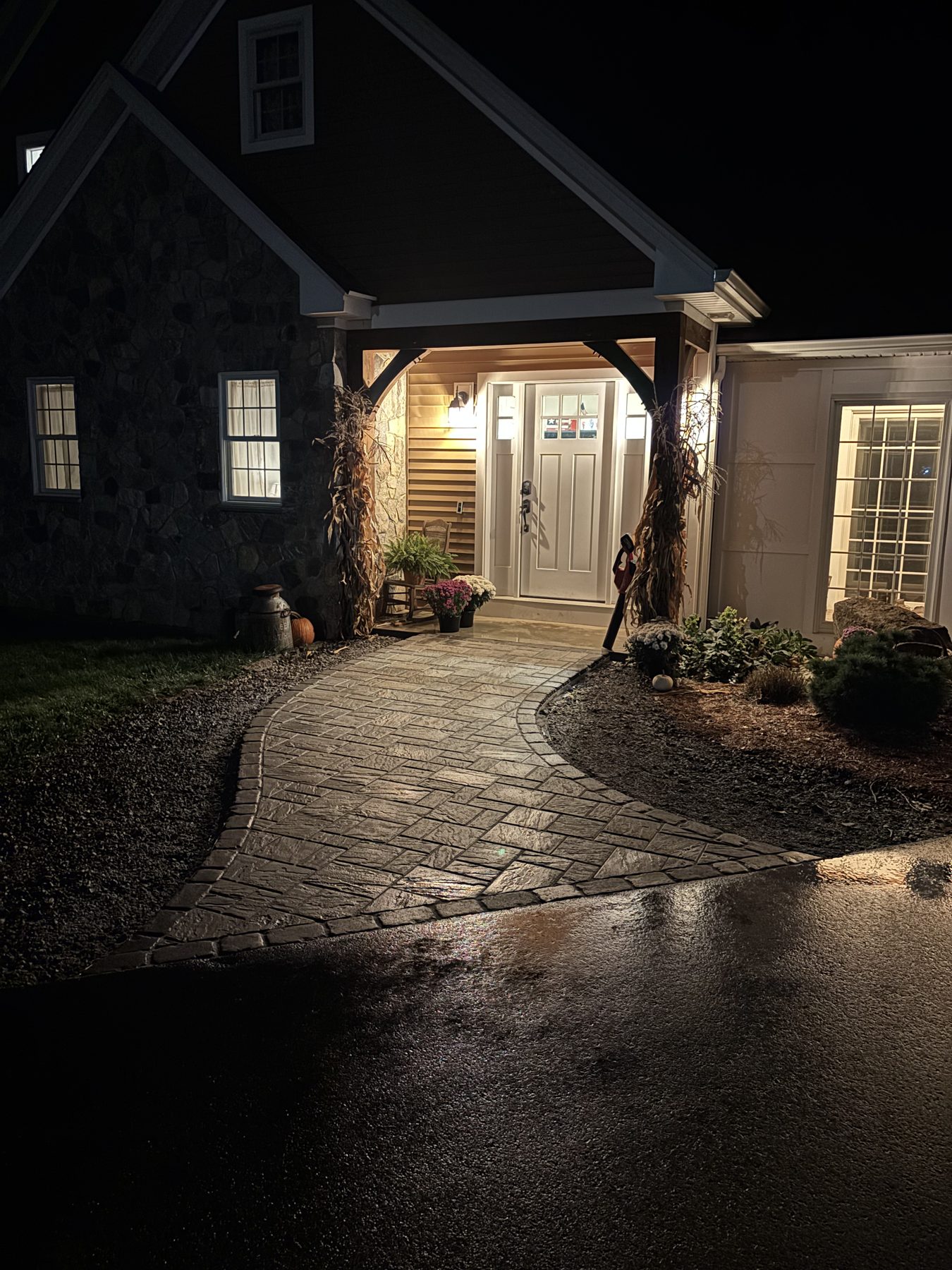 Paver walkway and timber frame entry lit at night